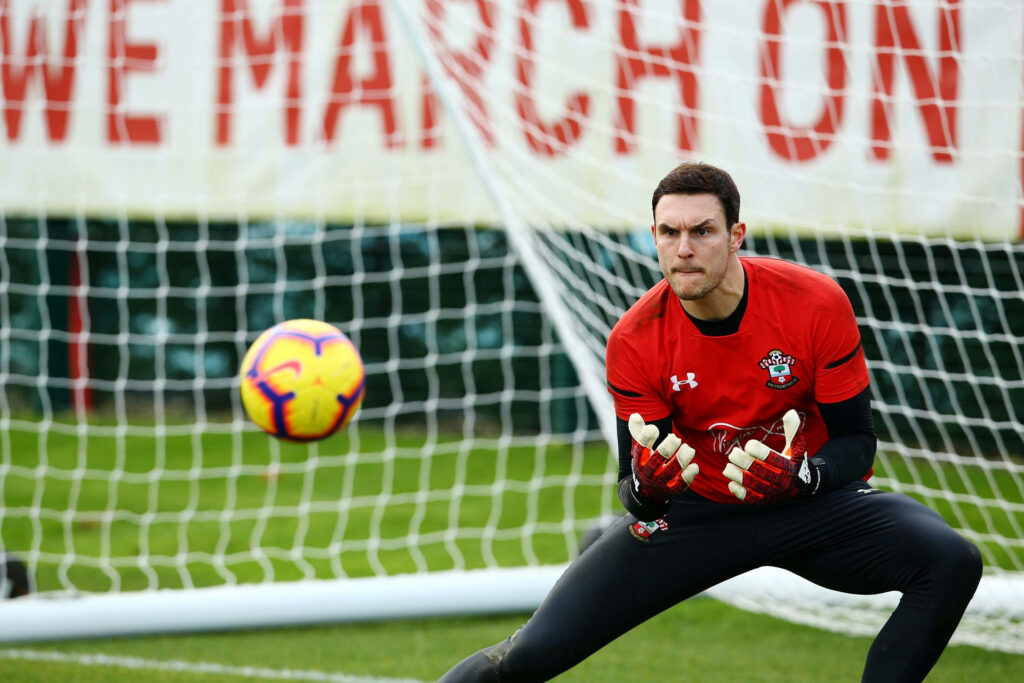 Alex McCarthy focused training to catch football near goal net in intense goalkeeper practice session Wallpaper