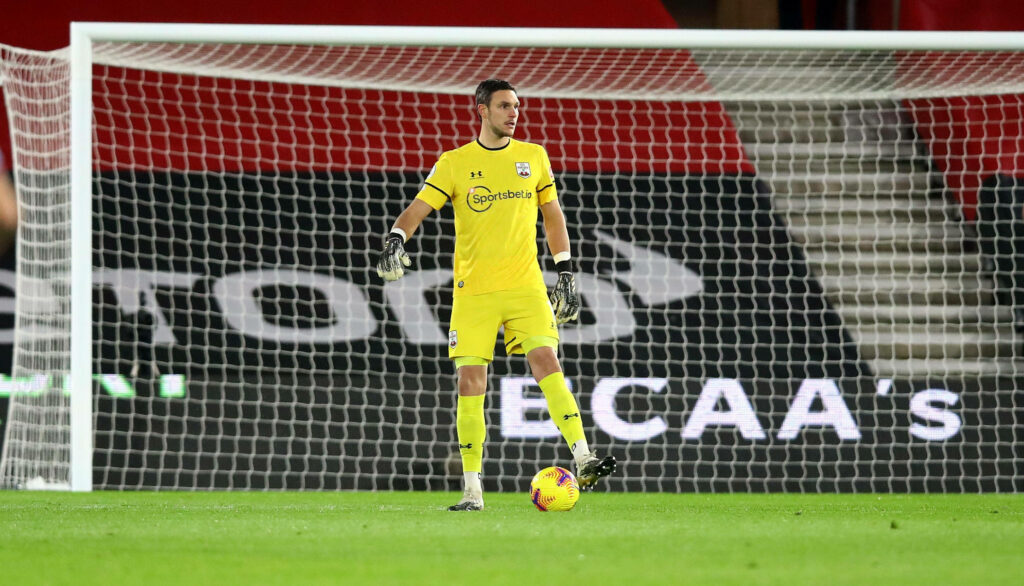 Alex McCarthy in bright yellow goalkeeper jersey ready on soccer field in front of goal during match Wallpaper