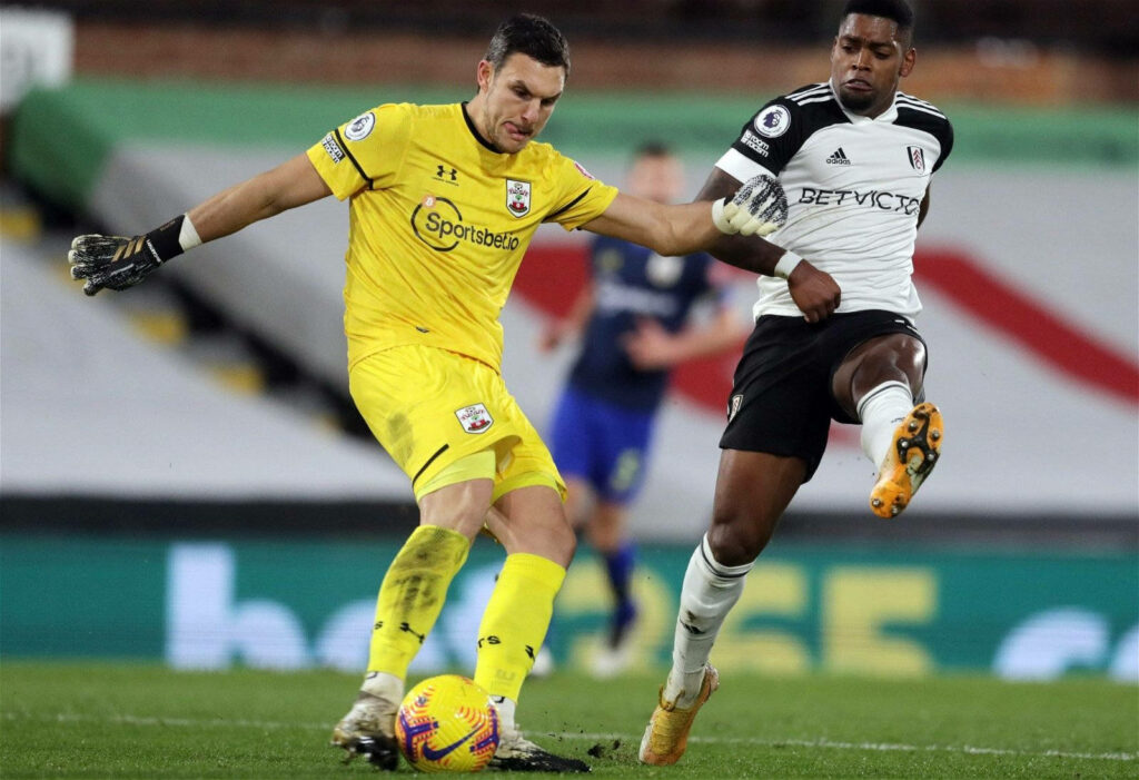Alex McCarthy and Ivan Cavaleiro focused in intense football match action on vibrant wallpaper background
