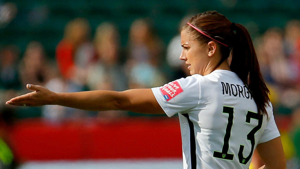 Alex Morgan US Soccer Team number 13 in action focused on the field with wallpaper background