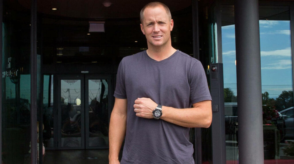 Alex Norén casual style in t-shirt standing before modern building wallpaper background