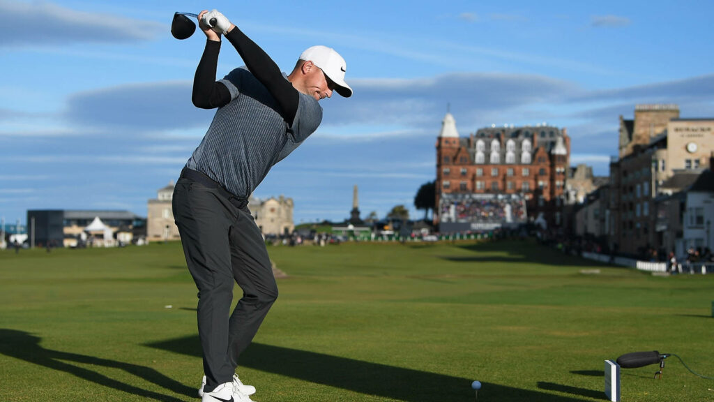 Dynamic Golf Wallpaper: Alex Noren Mid-Swing on Historic Course