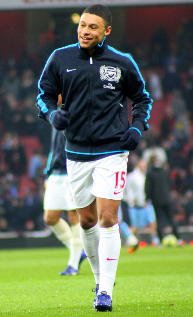 Alex Oxlade-Chamberlain running on football field in Arsenal training kit showing athleticism Wallpaper