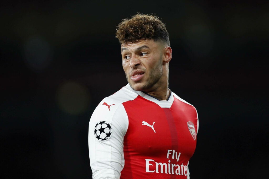 Alex Oxlade-Chamberlain in Arsenal kit glancing back during intense football match action wallpaper