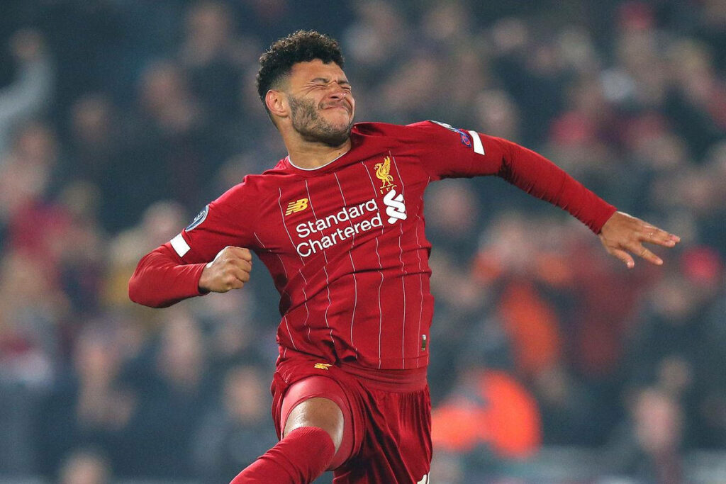 Alex Oxlade Chamberlain celebrates in Liverpool jersey airborne with cheering crowd background Wallpaper