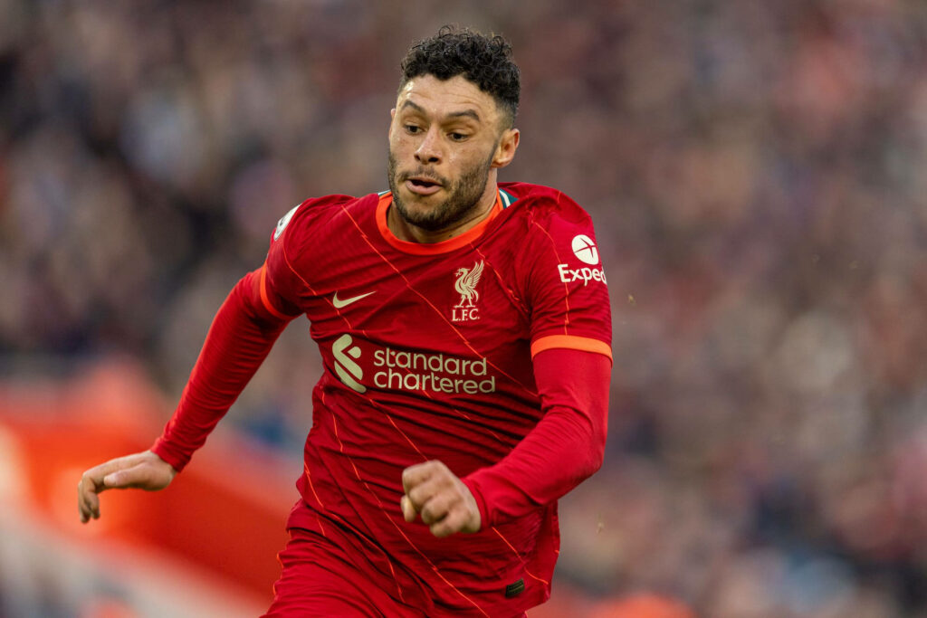 Alex Oxlade-Chamberlain running on field in Liverpool kit showing focus and athleticism wallpaper