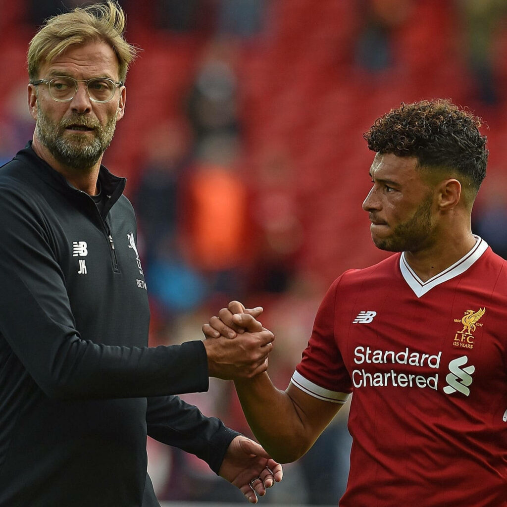 Alex Oxlade-Chamberlain and Jurgen Klopp handshake on field showing Liverpool unity and determination Wallpaper