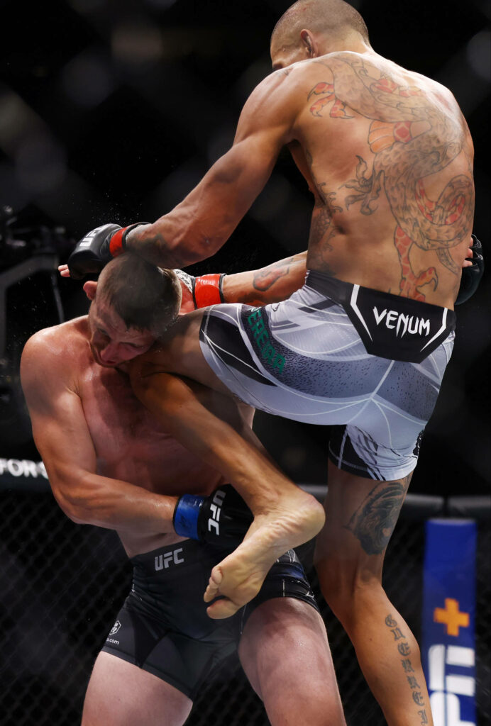 Alex Pereira executing a powerful flying knee strike in the UFC octagon intense fight action Wallpaper