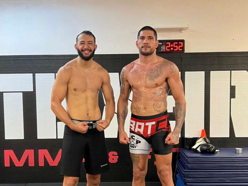 Alex Pereira and opponent stand strong after intense MMA fight in gym motivational wallpaper background