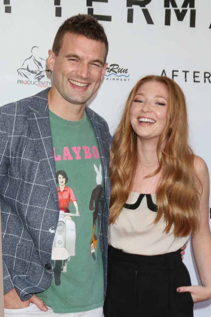 Alex Russell smiling with companion on red carpet joyful moment celebration event wallpaper background