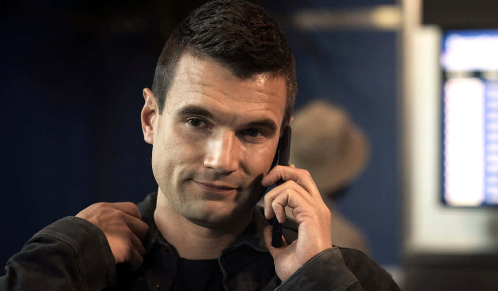 Alex Russell smiling warmly on phone relaxed approachable atmosphere wallpaper background