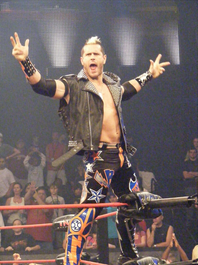 Alex Shelley striking dynamic pose on top rope wrestling ring entrance energetic charismatic Wallpaper