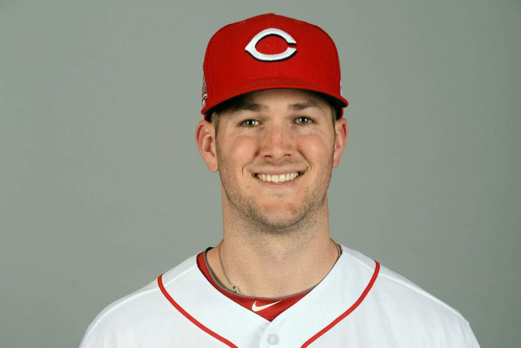 Close-up of Alex Wood smiling in Cincinnati Reds cap and uniform on gray background wallpaper