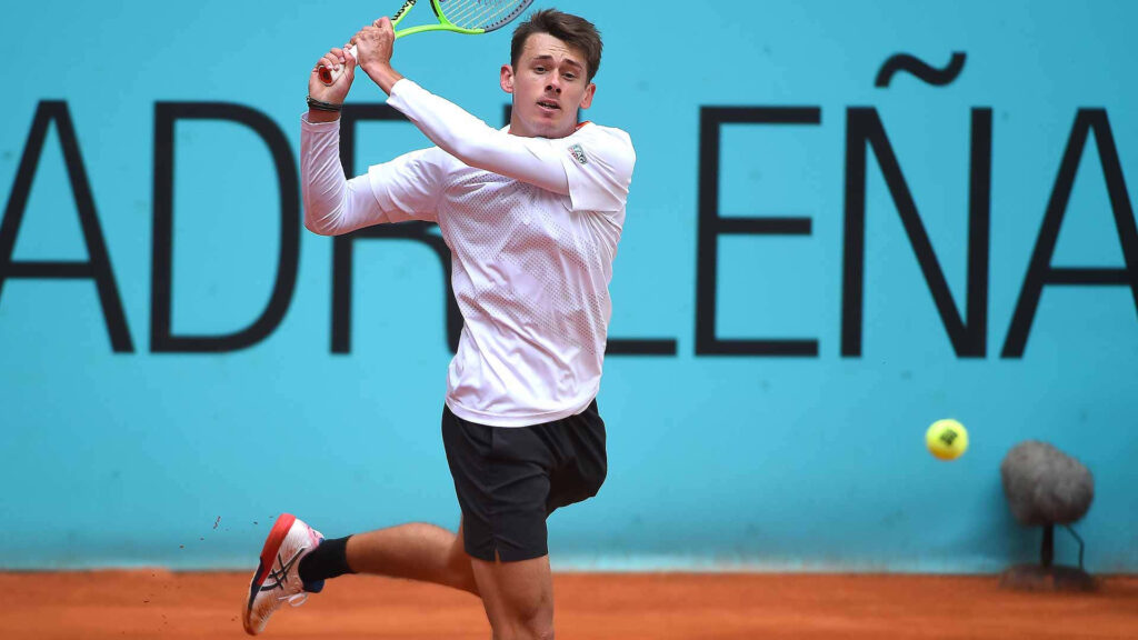 Alex de Minaur tennis action on clay court focused return professional match wallpaper background
