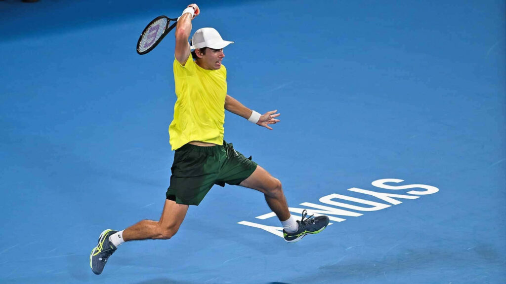 Alex de Minaur leaps powerfully on tennis court showing athleticism and intense action shot Wallpaper
