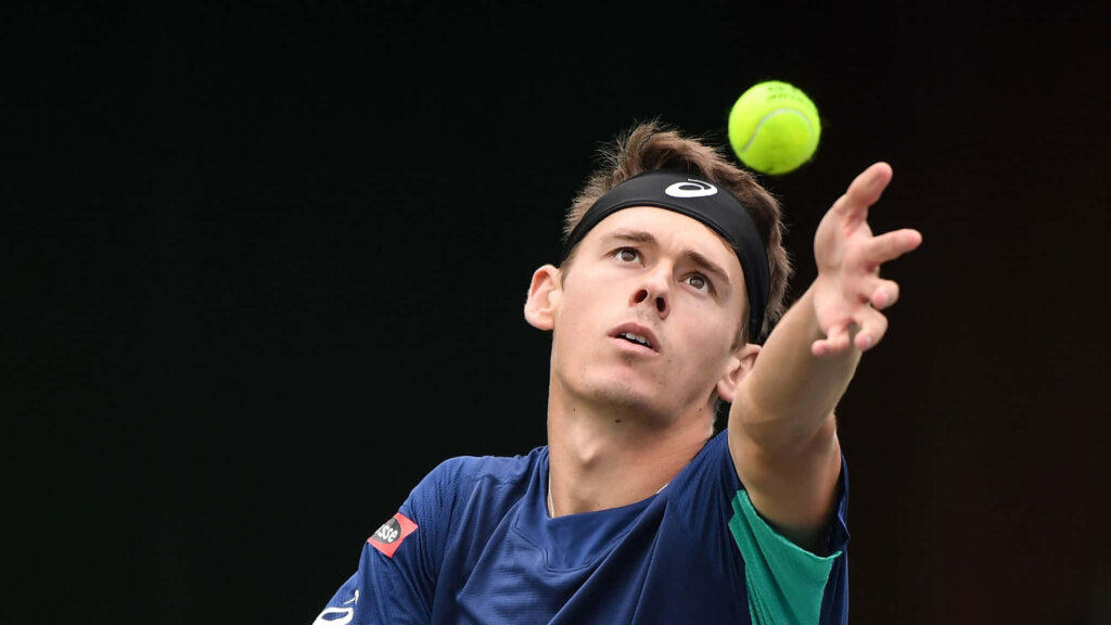 Alex de Minaur serving intensely during a tennis match dynamic action wallpaper background