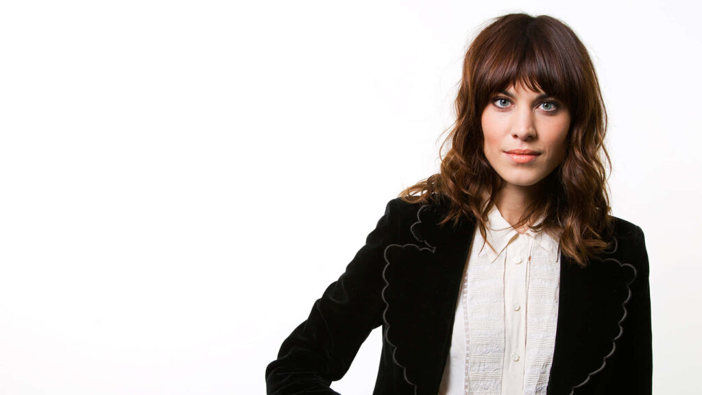 Alexa Chung fashion icon in chic outfit exuding contemporary elegance on minimalist wallpaper background