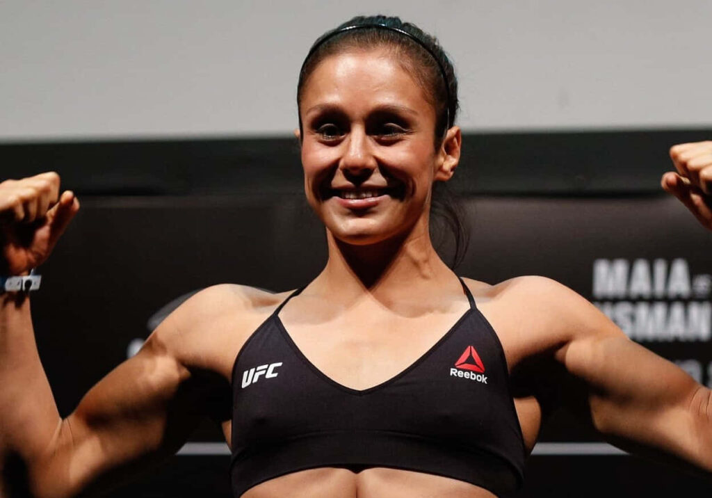 Alexa Grasso flexes muscles confidently in UFC backdrop showcasing strength and determination wallpaper