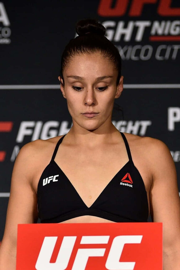 Alexa Grasso focused at UFC weigh-in in official fight gear with UFC branding background Wallpaper