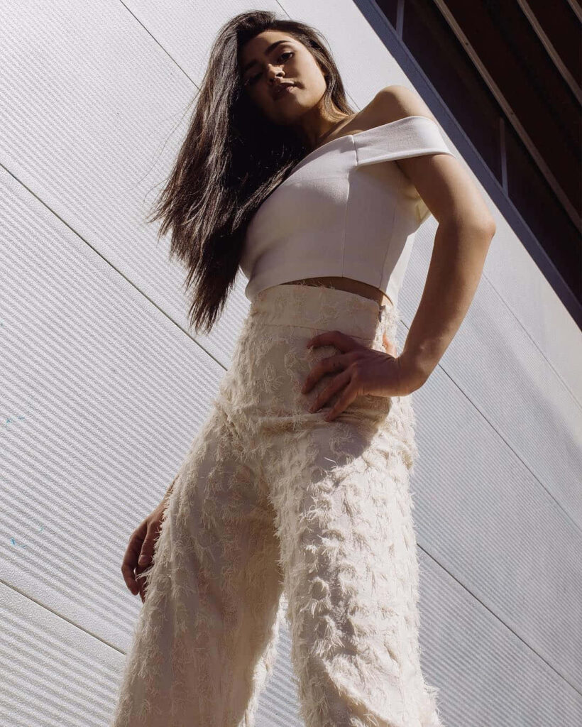 Alexa Rose Steele in urban chic off-shoulder top and high-waisted pants with city backdrop Wallpaper