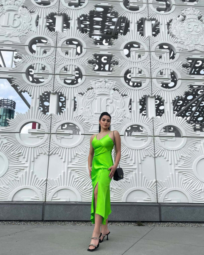 Alexa Rose Steele in vibrant green dress with geometric backdrop modern stylish wallpaper