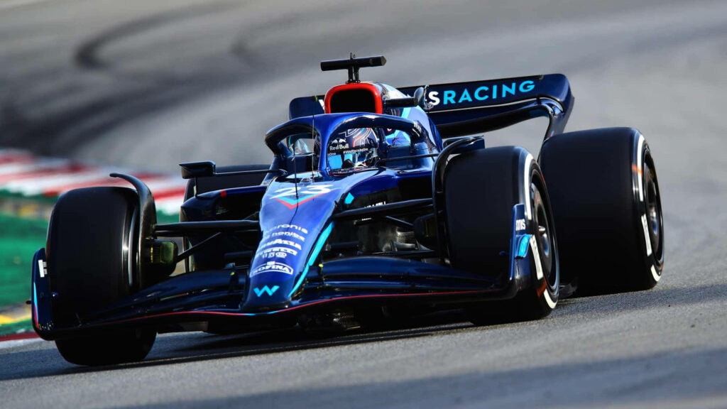 Alexander Albon racing his blue Formula One car at high speed during an intense Grand Prix race Wallpaper