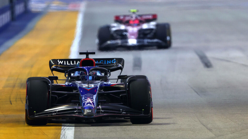 Alexander Albon driving Williams Formula 1 car at high speed with rival close behind on track Wallpaper