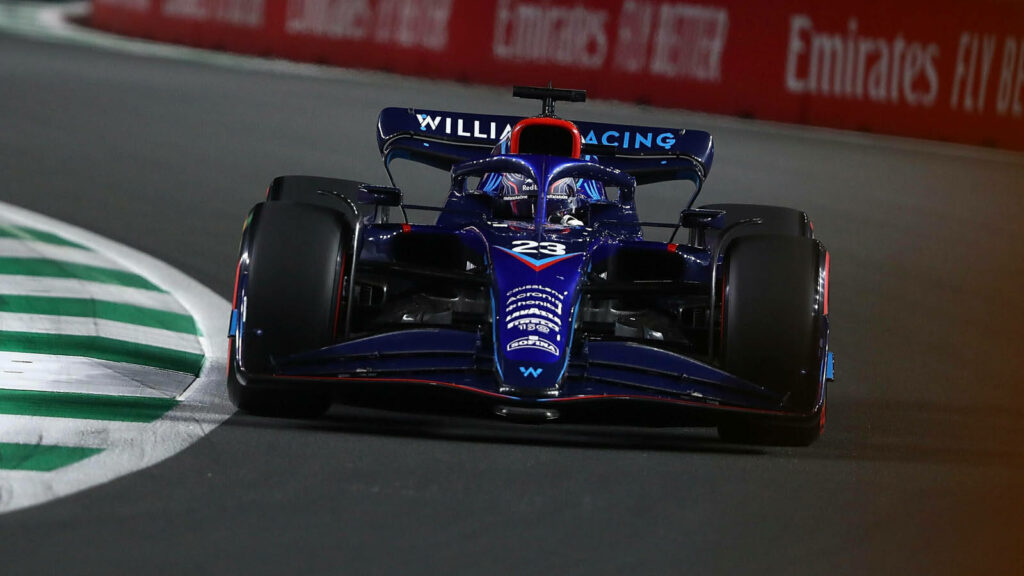 Alexander Albon racing in blue Williams Formula 1 car blazing down high speed racetrack wallpaper