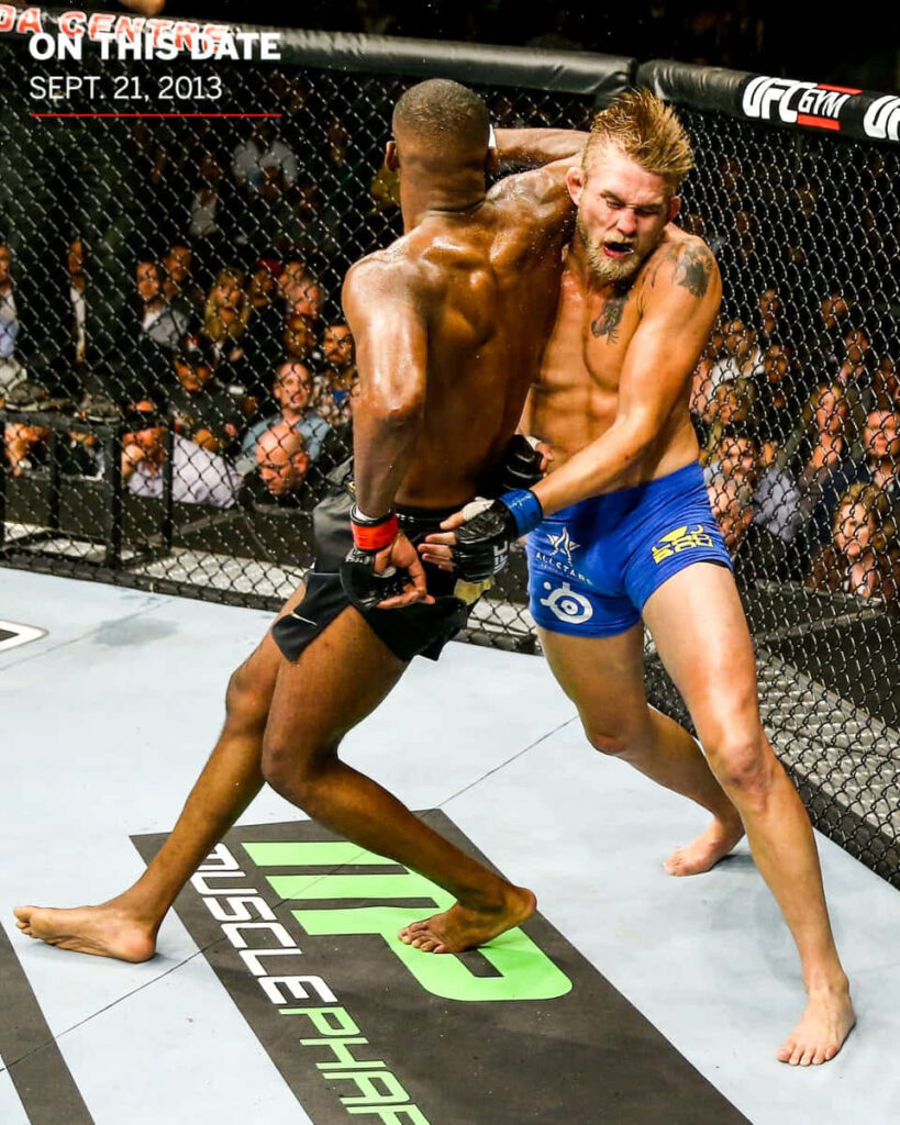 Alexander Gustafsson defending against Jon Jones elbow strike in intense UFC fight octagon action Wallpaper