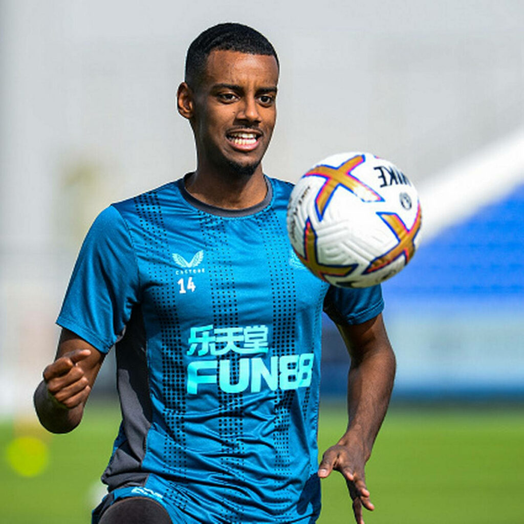Alexander Isak training on football field focused on ball showing determination and skill wallpaper