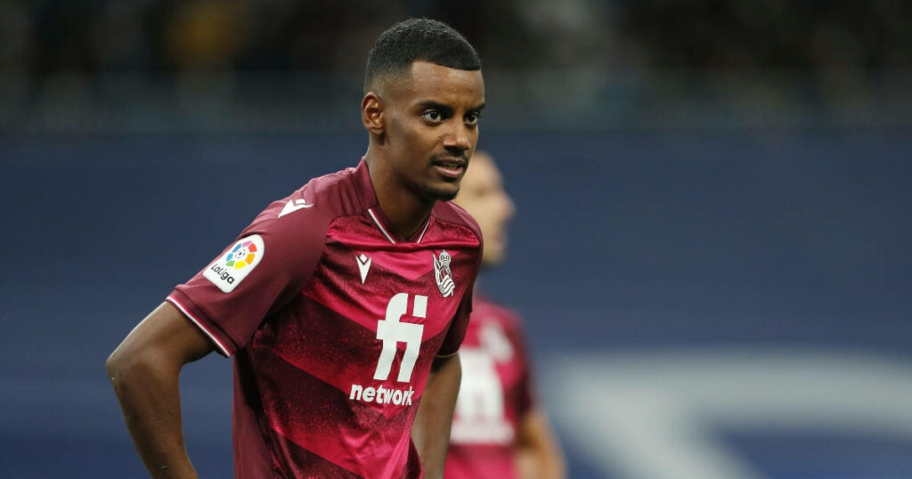 Alexander Isak in maroon Real Sociedad jersey poised on football field wallpaper background