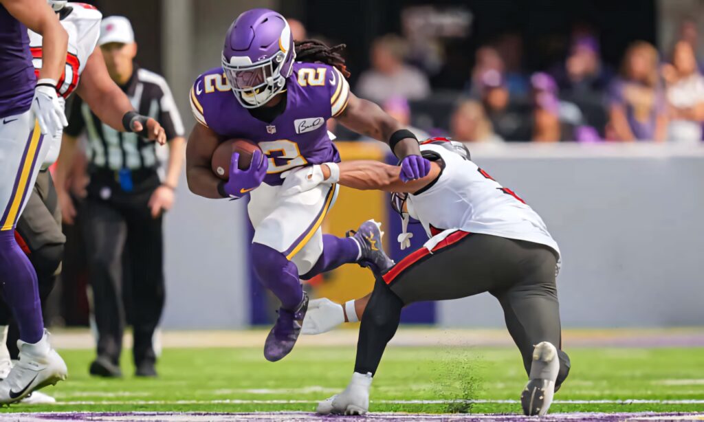 Alexander Mattison charges past defender showing speed and agility in intense NFL game wallpaper