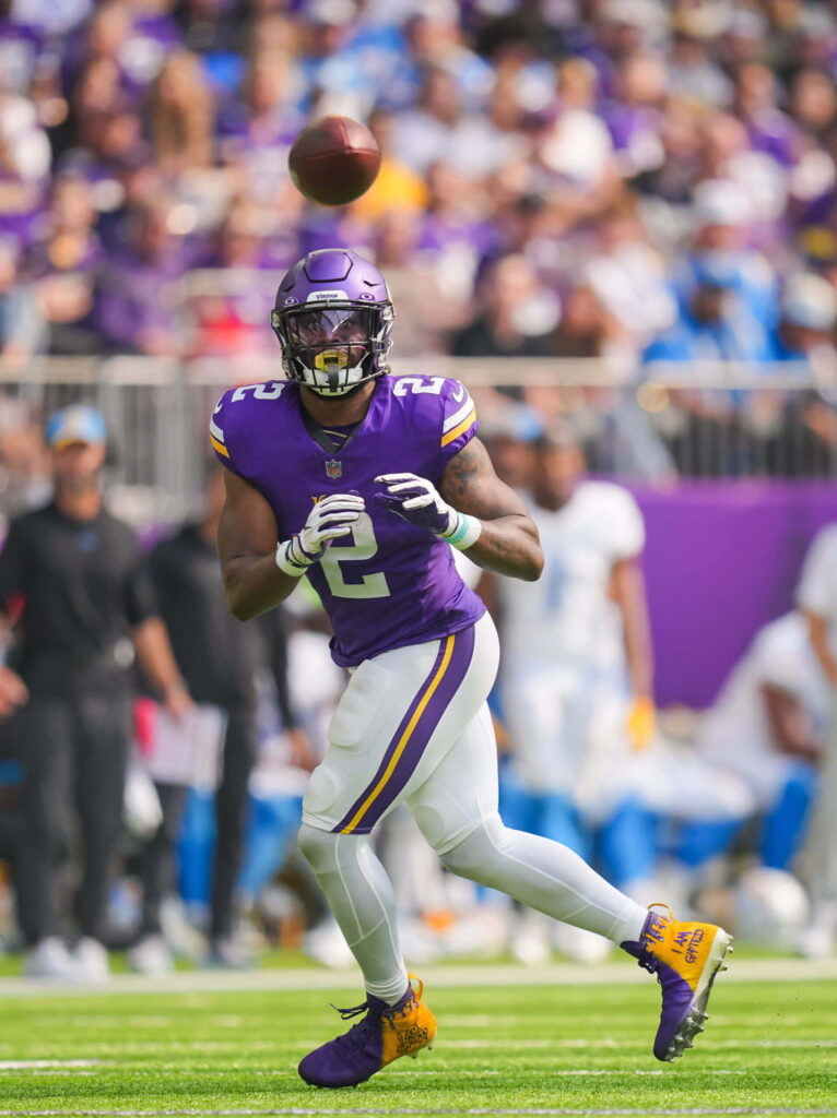 Alexander Mattison catching football in Minnesota Vikings uniform during intense game action wallpaper
