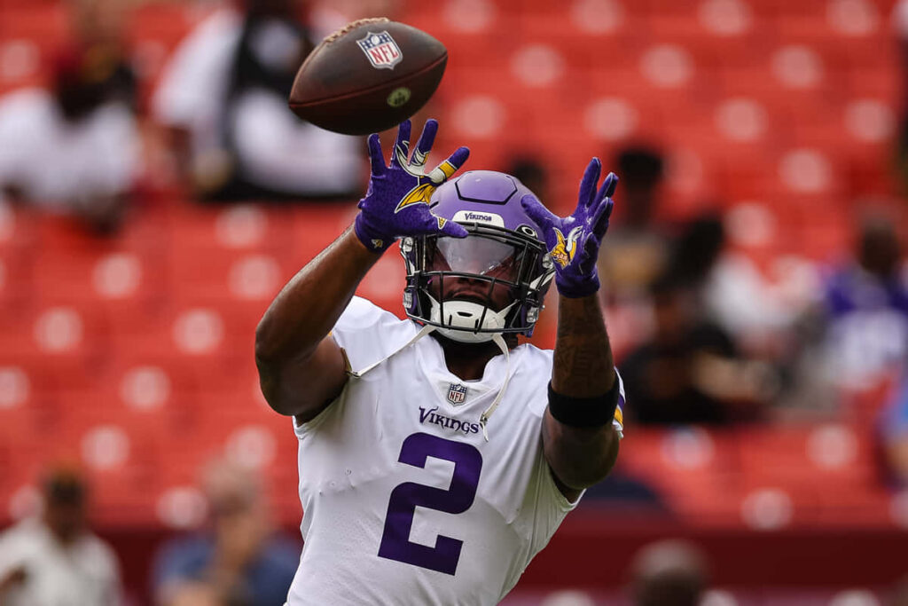 Alexander Mattison Minnesota Vikings catching football showing focus and athletic skill game action Wallpaper