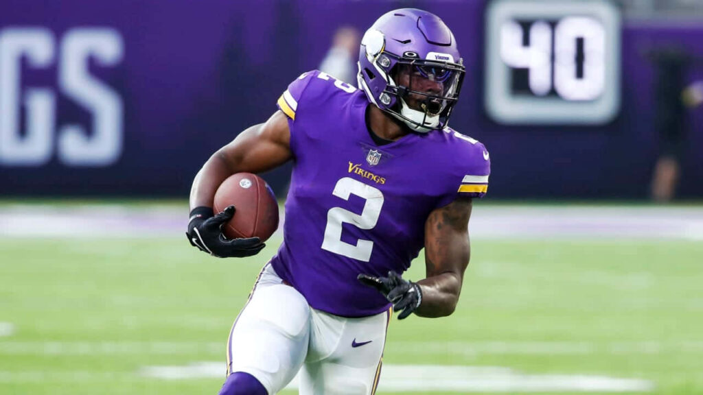 Alexander Mattison Minnesota Vikings running back powers forward in dynamic football action wallpaper