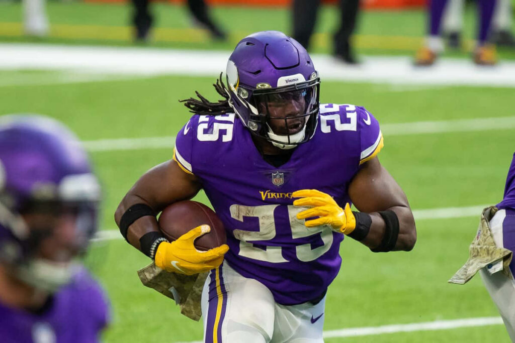 Minnesota Vikings running back Alexander Mattison rushing with football in intense game action Wallpaper