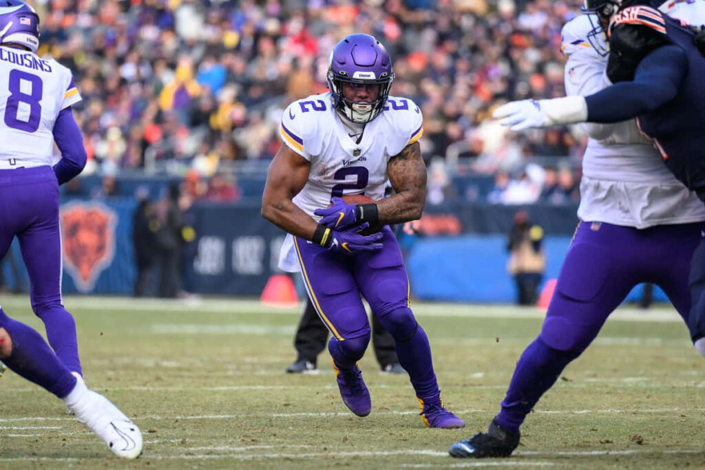 Alexander Mattison in Minnesota Vikings uniform running back powering through field action wallpaper