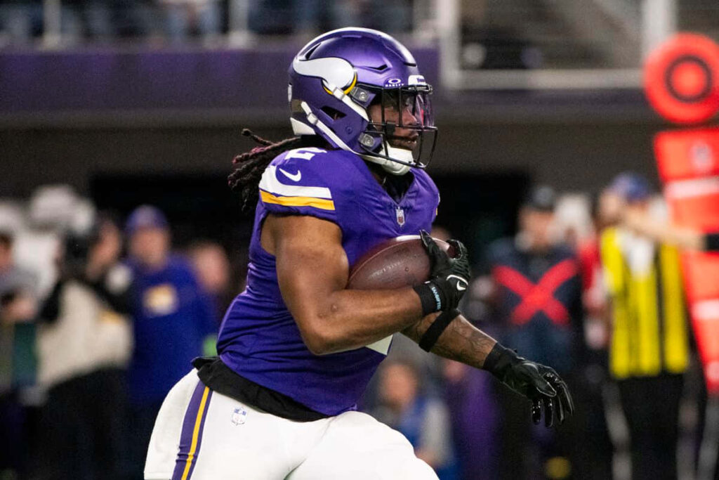 Alexander Mattison Vikings running back sprinting in full stride during intense game action wallpaper