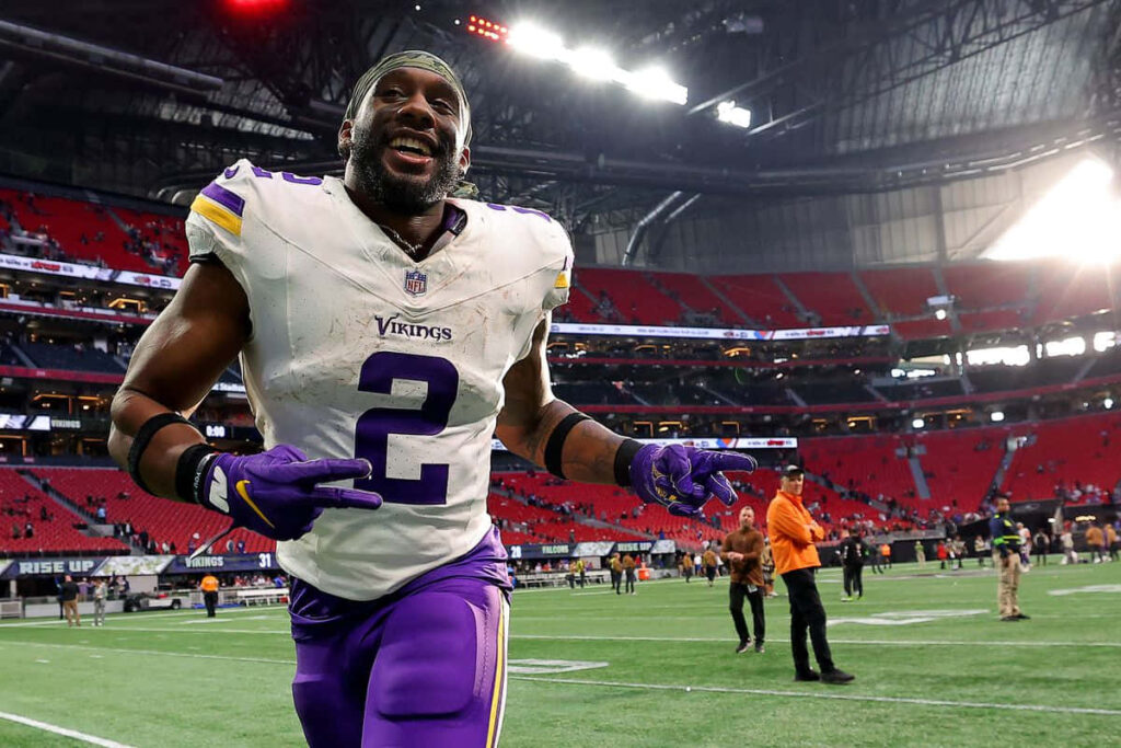 Alexander Mattison Minnesota Vikings celebrating victory on vibrant stadium field after game Wallpaper