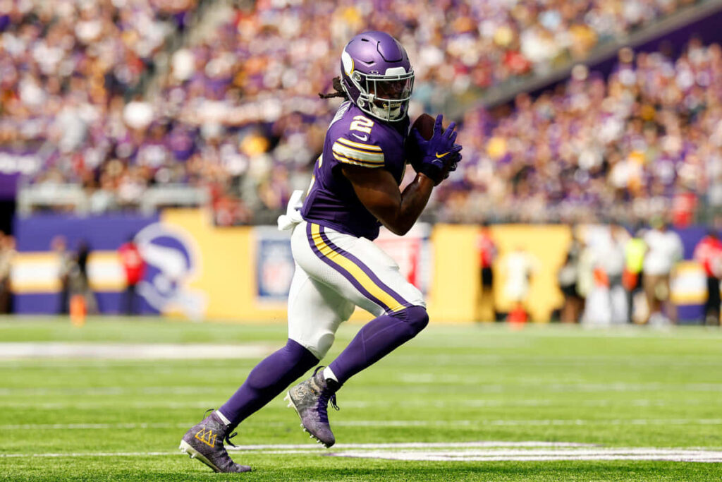 Alexander Mattison sprinting full speed on football field showcasing athleticism dynamic action Wallpaper