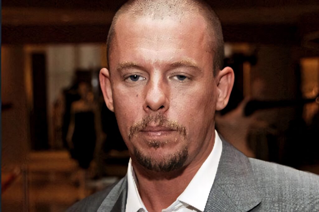Alexander McQueen in a stylish gray suit iconic fashion designer wallpaper background