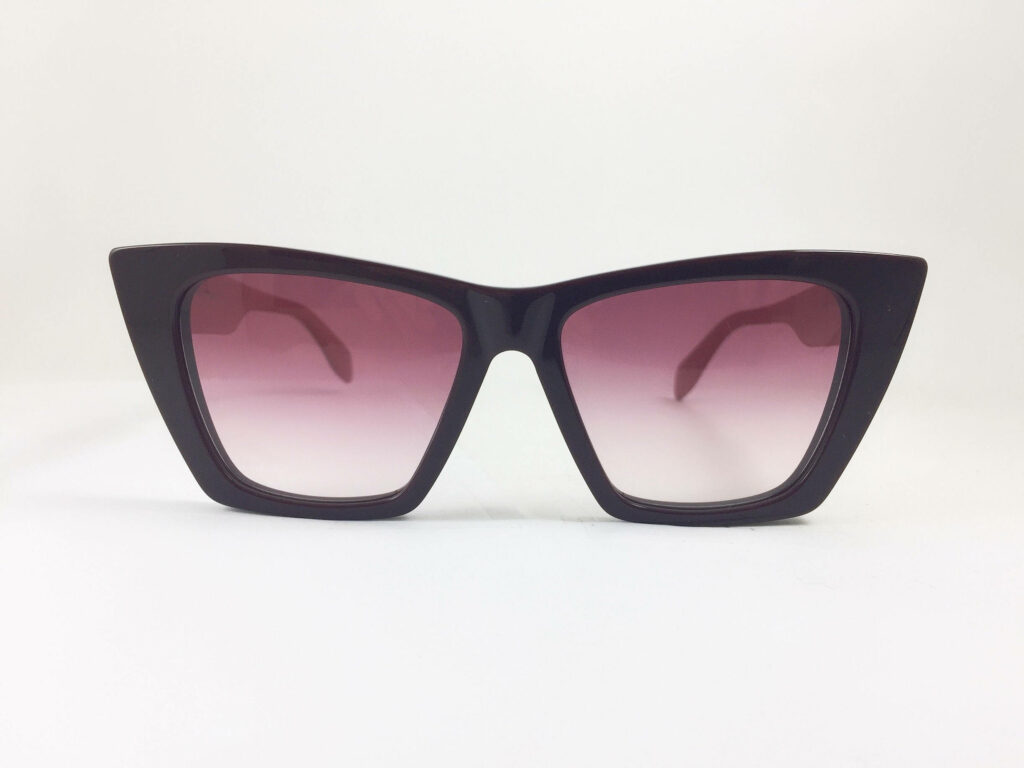 Alexander McQueen retro cat eye sunglasses with gradient lenses on stylish wallpaper background