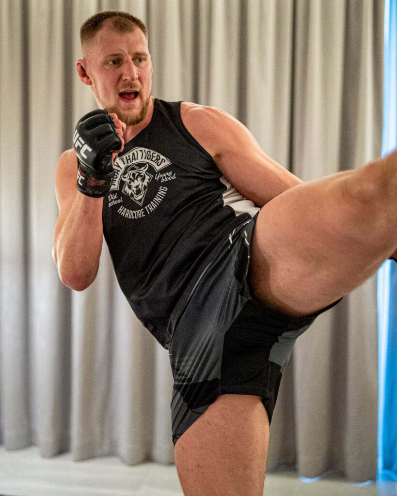Alexander Volkov UFC fighter high kick showcasing strength focus dynamic wallpaper background