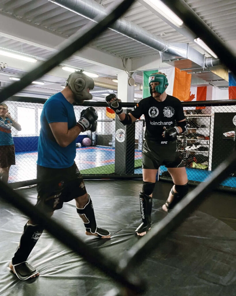 Alexander Volkov training in full gear behind railing showing focus and determination gym session Wallpaper