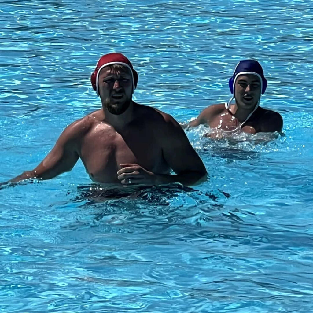 Alexander Volkov in red swim cap focused in pool playing water polo match wallpaper background