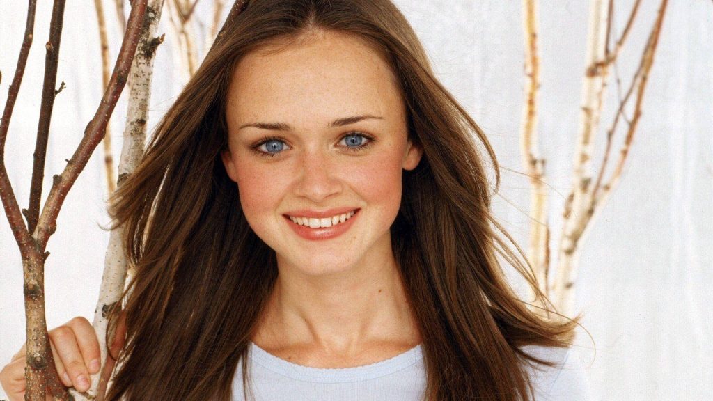 Alexis Bledel as Rory Gilmore smiling in sunlit Birch tree background Gilmore Girls wallpaper