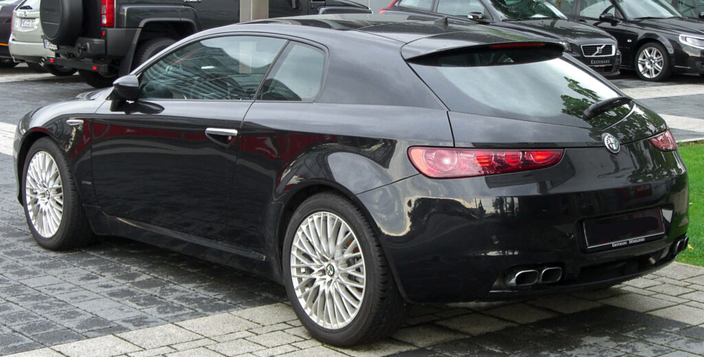 Alfa Romeo Brera black sporty car parked on scenic cobblestone road elegant design wallpaper