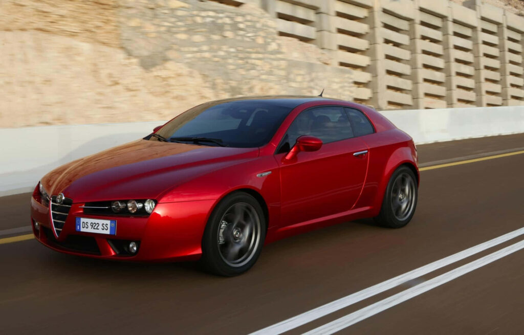Alfa Romeo Brera red sports car driving on scenic road with vibrant landscape background wallpaper
