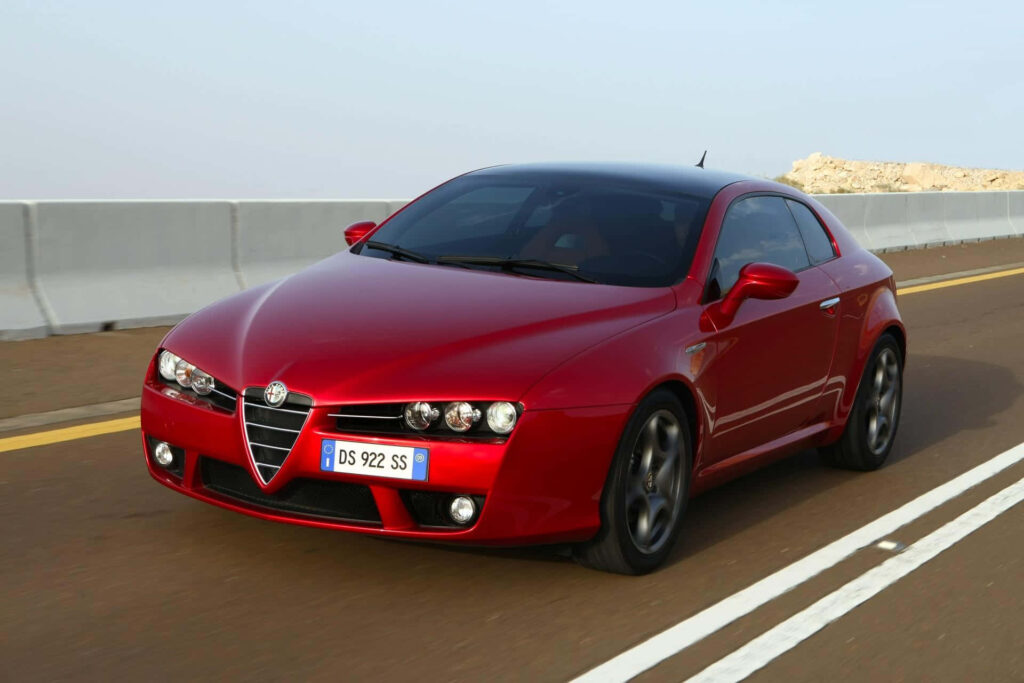 Red Alfa Romeo Brera driving on open road showcasing sporty design and sleek elegance wallpaper