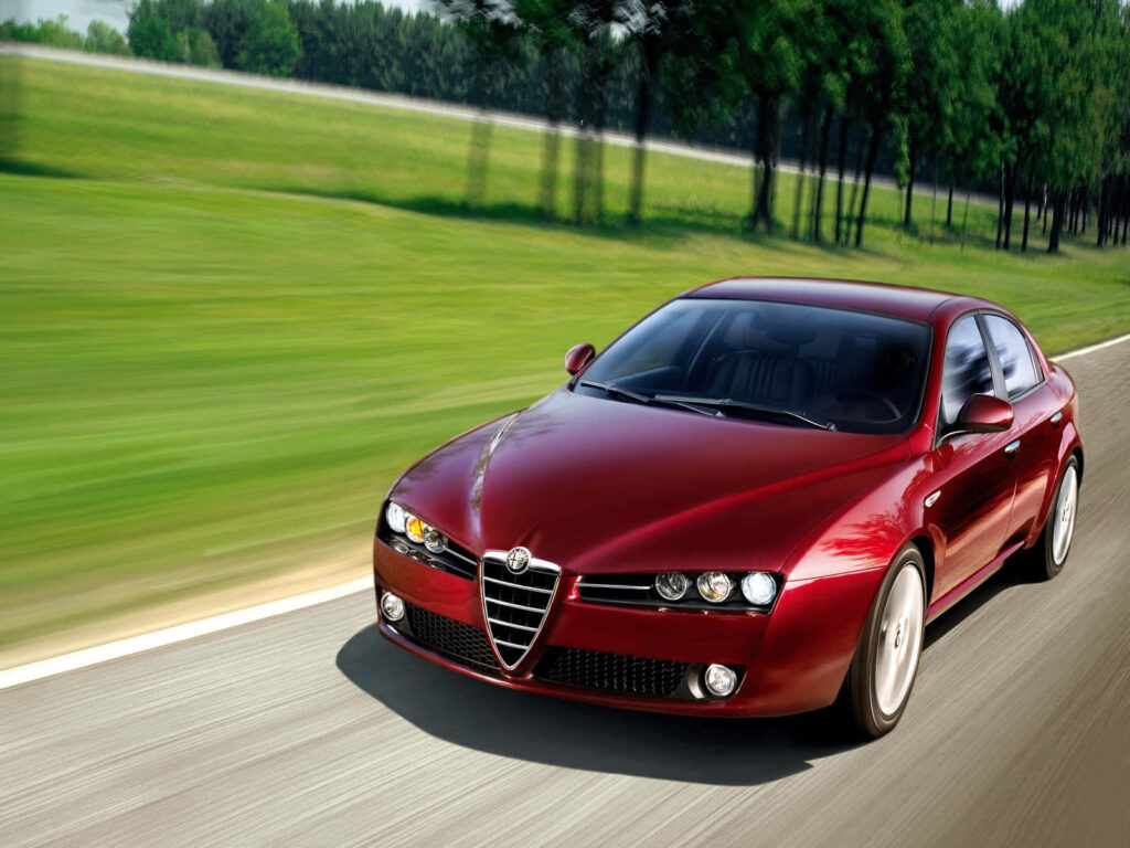 Red Alfa Romeo Brera speeding on scenic road with lush green backdrop dynamic performance wallpaper